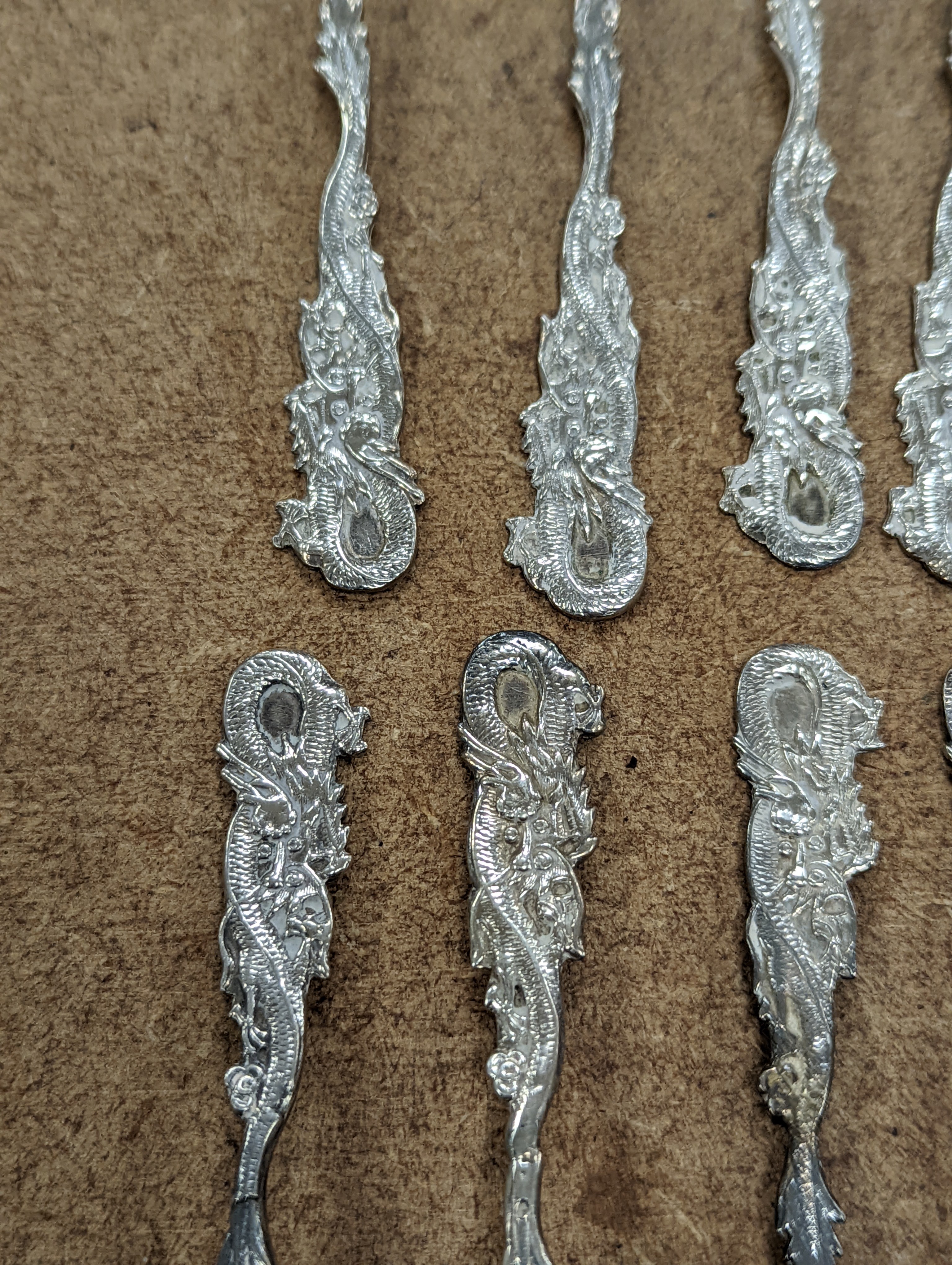 A set of twelve Chinese sterling tea forks, with dragon handles by YCCo and eleven similar teaspoons, 8oz.